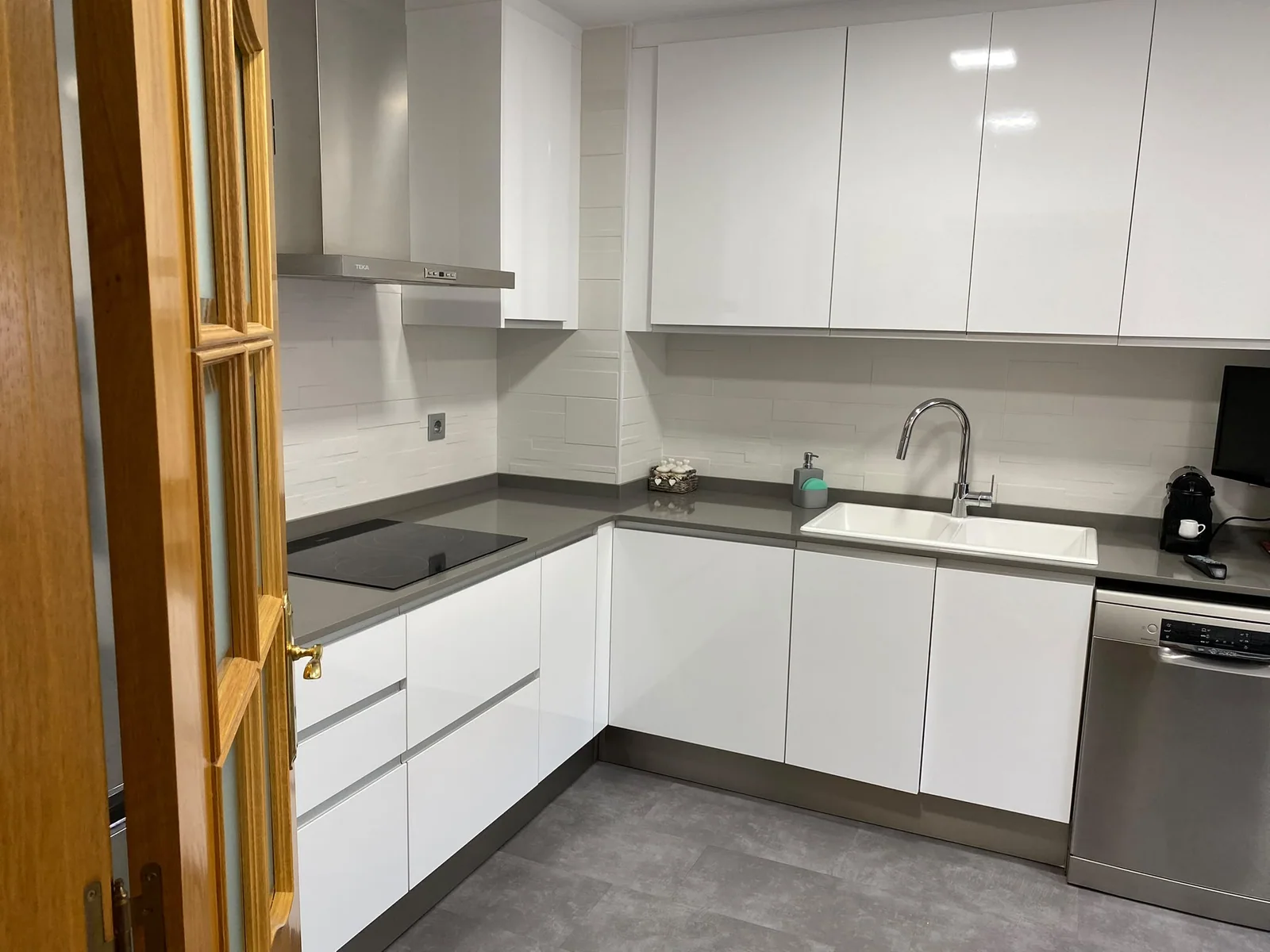 Cocina blanca en L con encimera gris y muebles altos de Grupo Diper